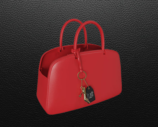 Red handbag with a keychain on a black textured background